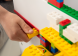 De zijrails van de LEGO speelgoedkist zijn ideaal om constructies tegenaan te bouwen